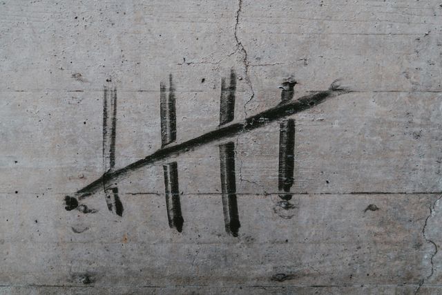 hash marks smeared in black on a cement wall